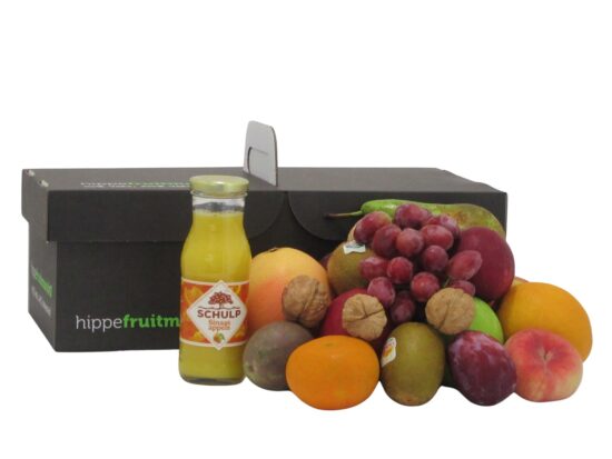 fruitmand gevuld met kleurrijk vers fruit en een glazen flesje Schulp sinaasappelsap van Hippefruitmand.nl.