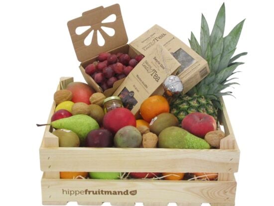 Fruitkist Groot met thee in houten krat, gevuld met mango, ananas, druiven, peren, appels, kiwi, walnoten, honing en groene en zwarte thee van hippefruitmand.nl