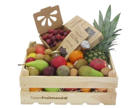 Fruitkist Groot met thee in houten krat, gevuld met mango, ananas, druiven, peren, appels, kiwi, walnoten, honing en groene en zwarte thee van hippefruitmand.nl