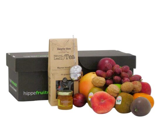 Verse fruitmand met seizoensfruit , zwarte thee en honing van Hippefruitmand