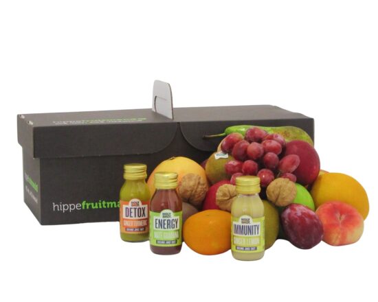 fruitmand 'Small' van Hippefruitmand.nl, rijkelijk gevuld met vers, kleurrijk fruit en drie flesjes gember-gembershots