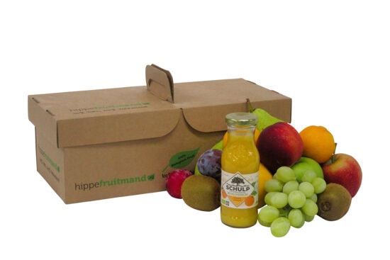 Fruitmand Puur Natuur met vers seizoensfruit en flesje Schulp sinaasappelsap in duurzame kartonnen doos van hippefruitmand.nl