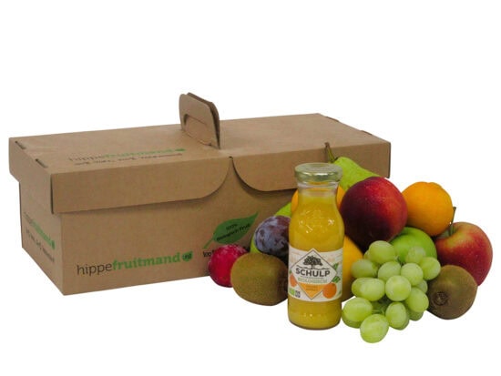 Fruitmand Puur Natuur met vers seizoensfruit en flesje Schulp sinaasappelsap in duurzame kartonnen doos van hippefruitmand.nl