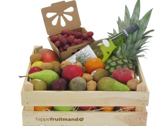 Fruitkist Groot met witte wijn in houten krat, gevuld met mango, ananas, druiven, peren, appels, kiwi en walnoten van hippefruitmand.nl