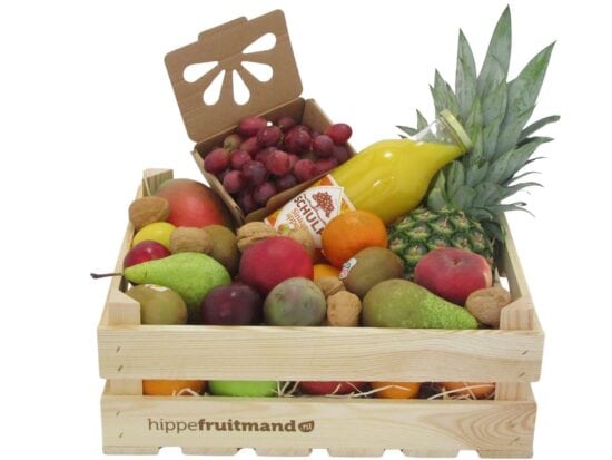 Fruitkist Groot met sinaasappelsap in houten krat, gevuld met mango, ananas, druiven, peren, appels, kiwi en walnoten van hippefruitmand.nl