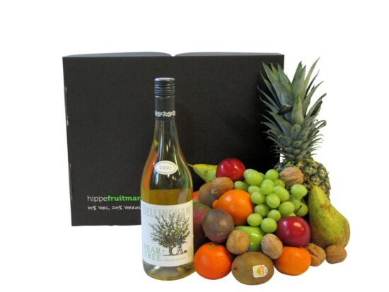 Fruitmand groot gevuld met vers fruit en een fles witte wijn
