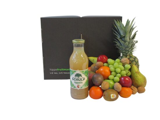 Luxe fruitmand gevuld met appels, peren, druiven, kiwi's en een fles Schulp appelsap - Hippefruitmand.nl.