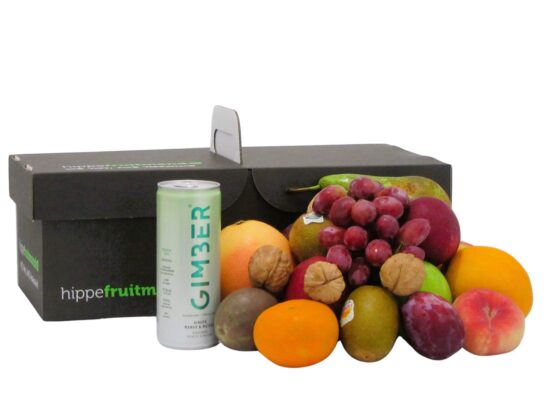 fruitmand gevuld met vers seizoensfruit zoals appels, druiven en sinaasappels, met een blikje GIMBER Matcha gemberdrank