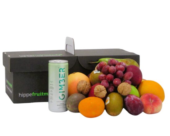 fruitmand gevuld met vers seizoensfruit zoals appels, druiven en sinaasappels, met een blikje GIMBER Matcha gemberdrank