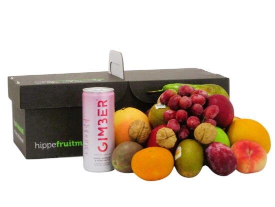fruitmand gevuld met vers seizoensfruit zoals appels, druiven en sinaasappels, met een blikje GIMBER Framboos gemberdrank