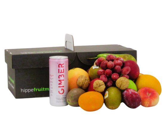 fruitmand gevuld met vers seizoensfruit zoals appels, druiven en sinaasappels, met een blikje GIMBER Framboos gemberdrank