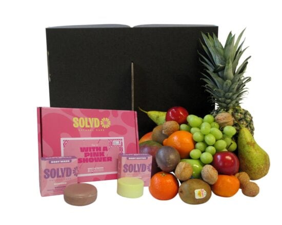 Duurzame fruitbox van Hippefruitmand gevuld met mango, ananas, druiven en appels, samen met de Pink Shower giftbox van SOLYD voor Pink Ribbon